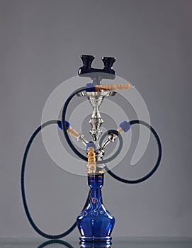 An old blue ceramic hookah on a grey background