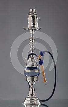 An old blue ceramic hookah on a grey background