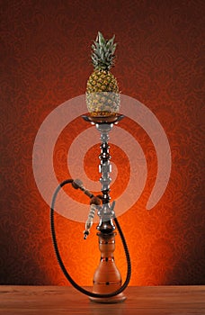 An old blue ceramic hookah on an orange background