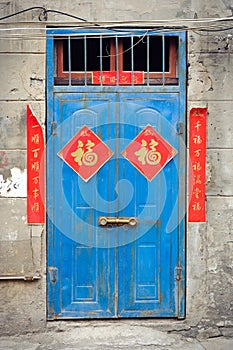 Old blue Chinese door with good fortune posters