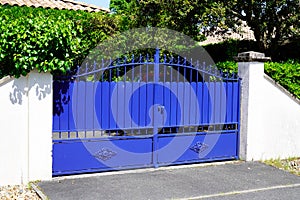 Old blue classic metal home gate at entrance of house portal garden