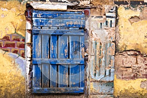 Old blue door against a yellow wall.