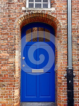 Old blue exterior door in brick wall