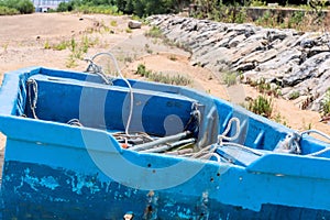 Old blue flat bottom boat on beach