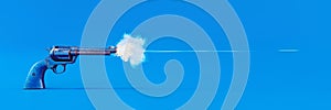Old blue handgun firing a bullet on blue background photo