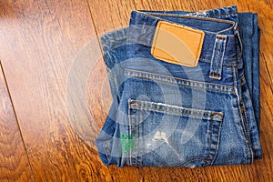 Old blue jeans with brown label on the belt smeared with green p