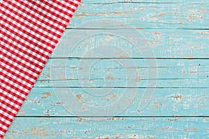 Old blue kitchen table background with red checked napkin