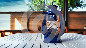 Old blue oil lamp on a wooden table