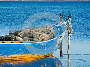 Old blue and orange fisherman boat with fish trap