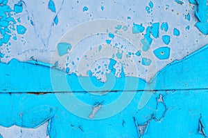 Old blue paint peeling from metal or concrete wall texture background.
