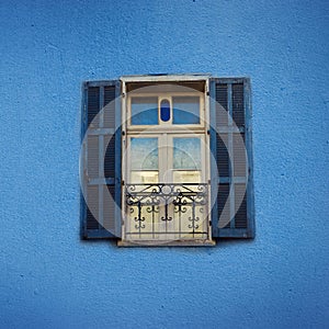 Old blue painted windows on concrete wall. Banner with copy space. Pop art concept, greek style window. Square crop