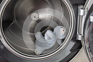 Old blue rabbit doll in a clean stainless steel drum washing machine