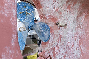 Blue sailboat propeller in a red painted hull