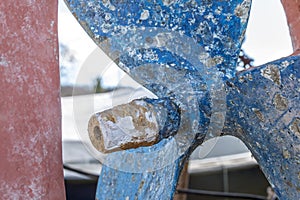 Blue sailboat propeller in a red painted hull