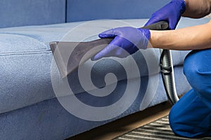 The old blue sofa is cleaned with a vacuum cleaner, with a wet cleaning function to restore the perfect look