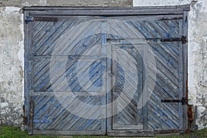 Old blue stripped wooden barn gate. Protect property and privacy. Front view