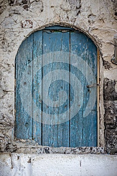 Old blue timber door in the scuffed wall