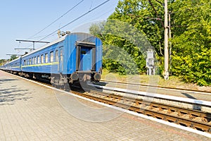 Old blue train is leaving the platfrom at the railway station