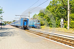 Old blue train is leaving the platfrom at the railway station