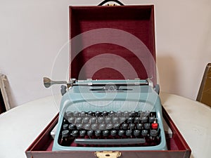 Old blue typing machine in a red box