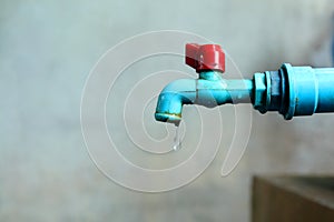 Old blue water tab have water drip out, concept shortage water in World for Water Day