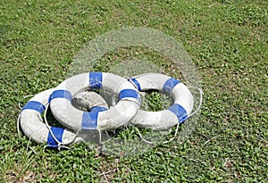 Old blue and white lifebelt ring on grass