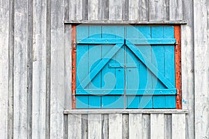 Old and blue window/barn doors on rustic grey and weathered wooden wall
