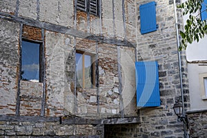 An old blue windows on the stone ancient building in a small French countryside town. Picturesque street in the medieval old town