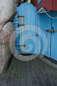 An old blue wooden door next to a rock formation