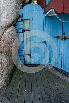 An old blue wooden door next to a rock formation