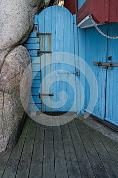 An old blue wooden door next to a rock formation