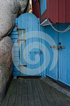 An old blue wooden door next to a rock formation