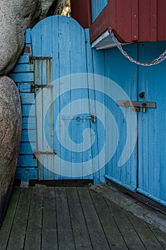 An old blue wooden door next to a rock formation