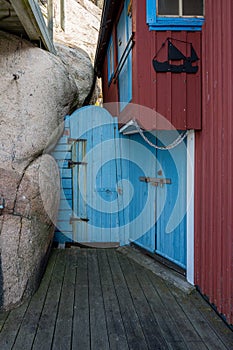 An old blue wooden door next to a rock formation