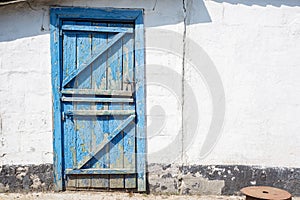 old blue wooden doors with white wall element. country style