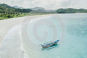 Old blue wooden traditional fishing boat on turquoise ocean surface in Indonesia