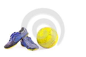 Old blue worn out futsal sports shoes and yellow futsal ball on white background football object isolated