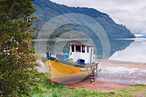 old boat anchored on the beach of the fjord of Puyuhuapi, Patagonia, Chile photo