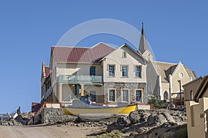 old boat ashore and picturesque building at historical town, Luderitz, Namibia