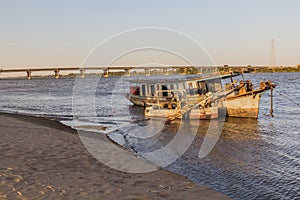 Old boat and a bridge over river Nile in Dongola, Sud photo