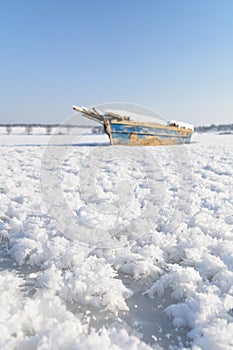 Old boat on ice. Vertical view with winter landscape composition