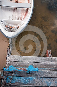 Old boat on an old wooden blue wharf on a river-lake. Top view, close up