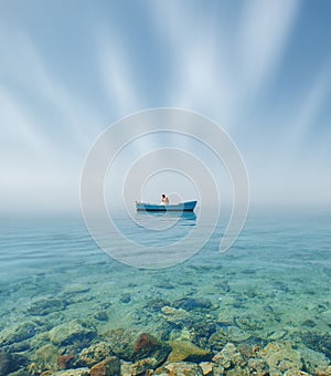 An old boat with one man abandoned sailing through the strange calm still sea