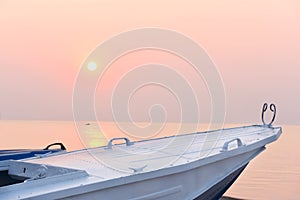 Old boat and pink dawn on the sea