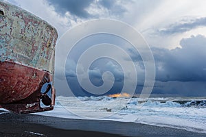 The Old Boat Pulled Ashore In The Storm Weather. Pebble, Rocky Dark Grey Shore. Sea Cloudy Sunset. Loneliness And Waiting. Hope