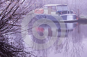 Old boat in the river on a foggy morning