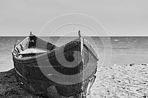 An old boat on the sand at Tuzla with the Black Sea on background in black and white