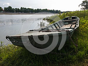 Old boat on shore near Sava river in Bosanski Brod, Bosnia and Herzegovina during sunny summer morning