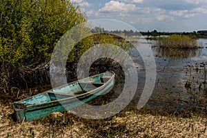 An old boat on the swampy bank of the former river