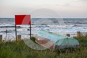 old boats at sunset on the seashore. a warning sign with a place for text